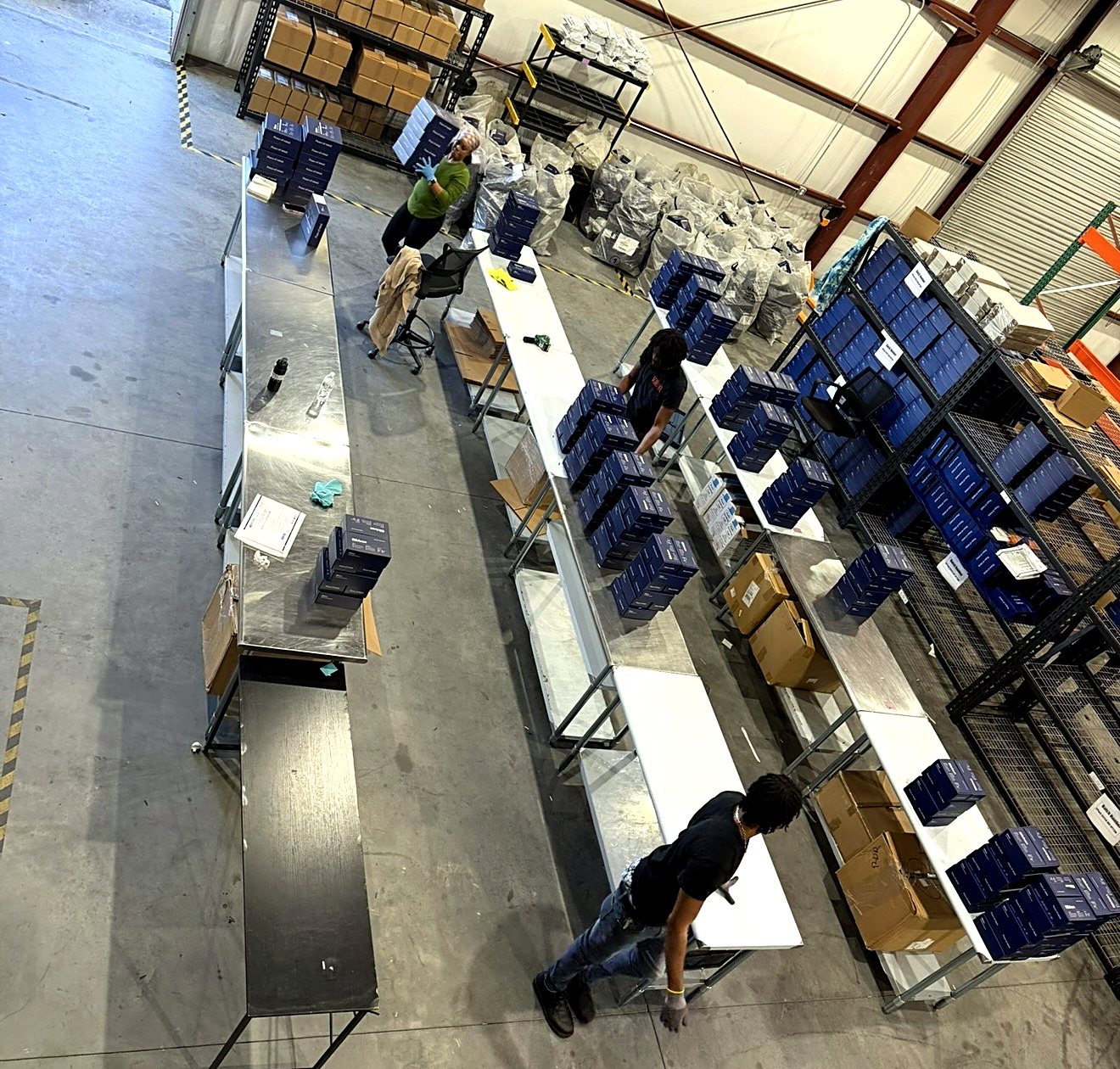 Distribution center team working at production tables with an organized fulfillment workflow
